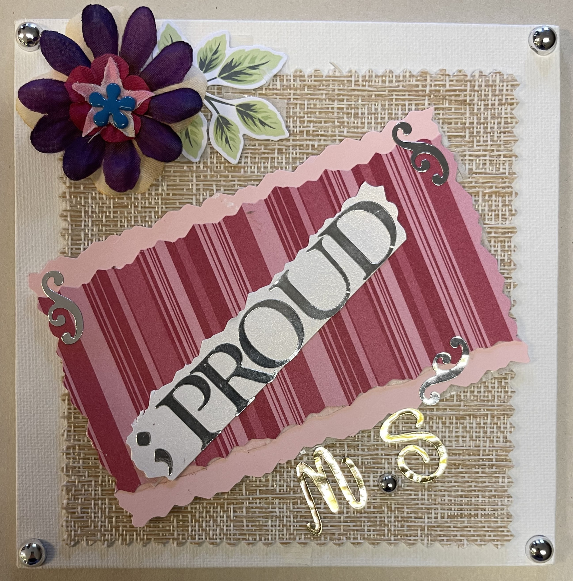 A decorated card with the guiding word 'Proud' in gold lettering, made in a Heard workshop.