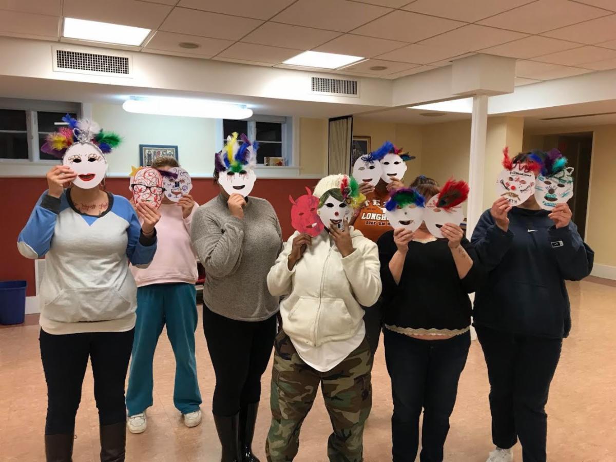 Participants hold decorated masks they created during a Heard mask-making workshop.