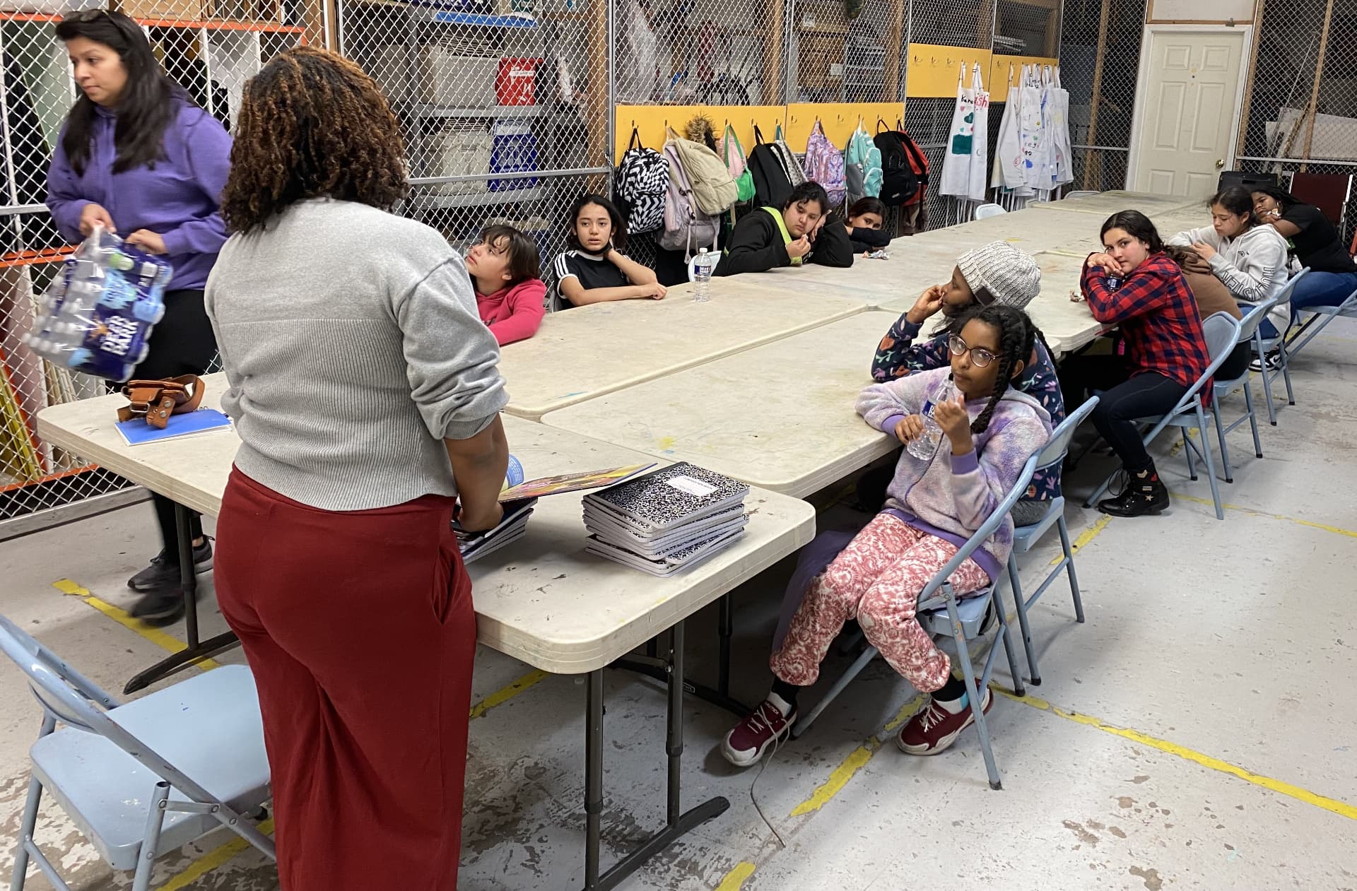 Young participants write together at a long table during a creative writing workshop.