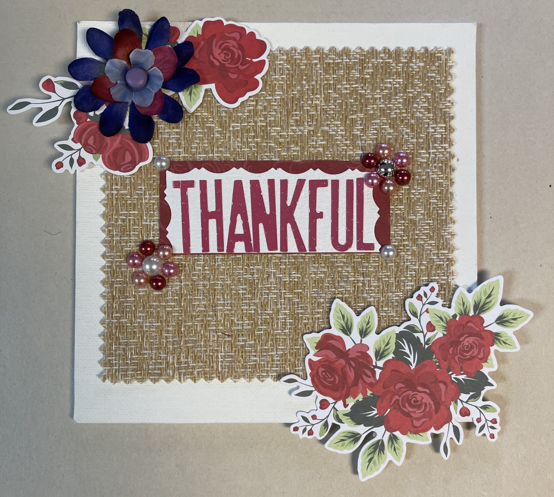 A handmade card decorated with paper flowers spelling the guiding word 'Thankful'.