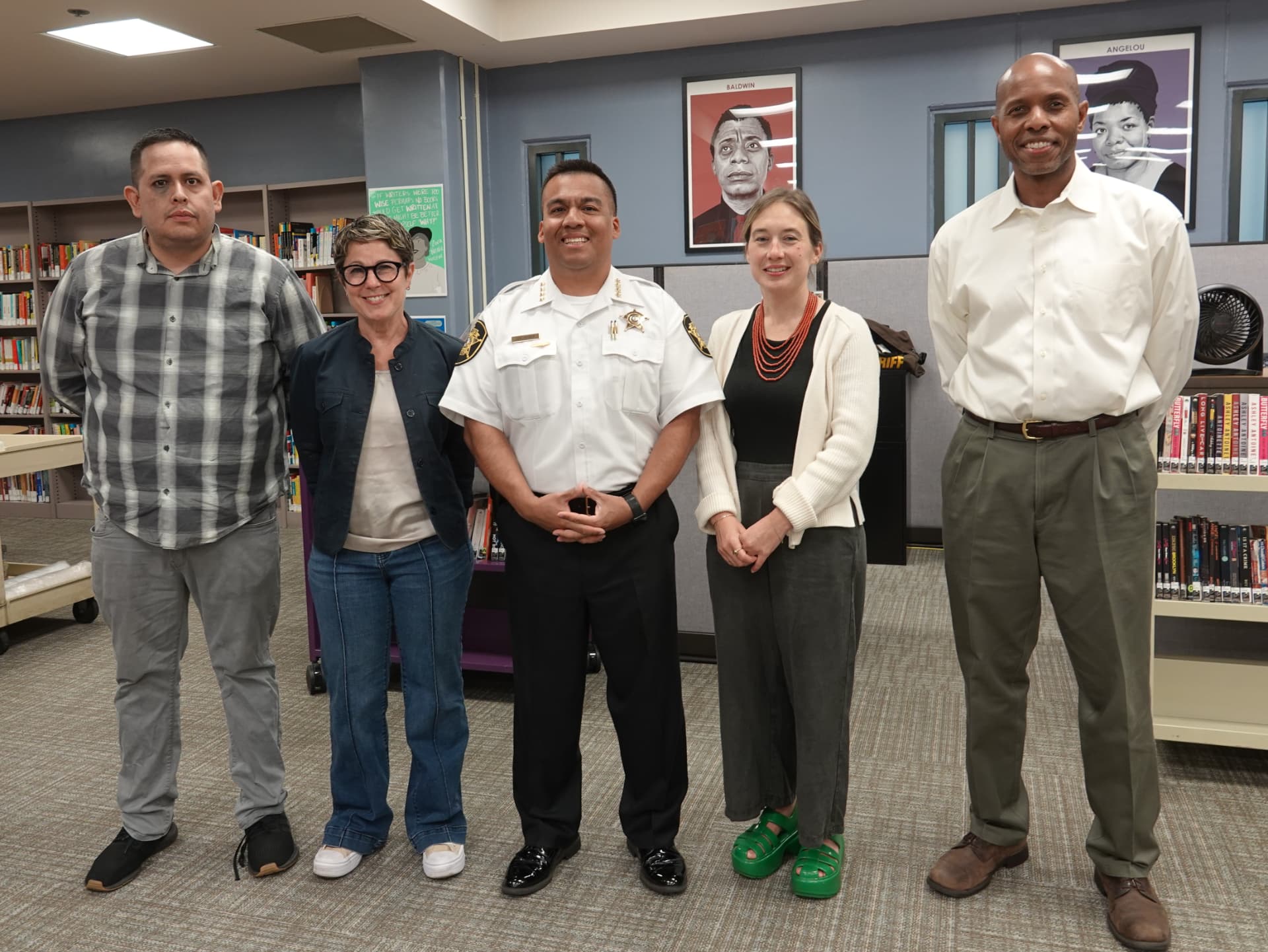 Judges and facility staff gather in a library before the 2025 Heard creative writing contest.