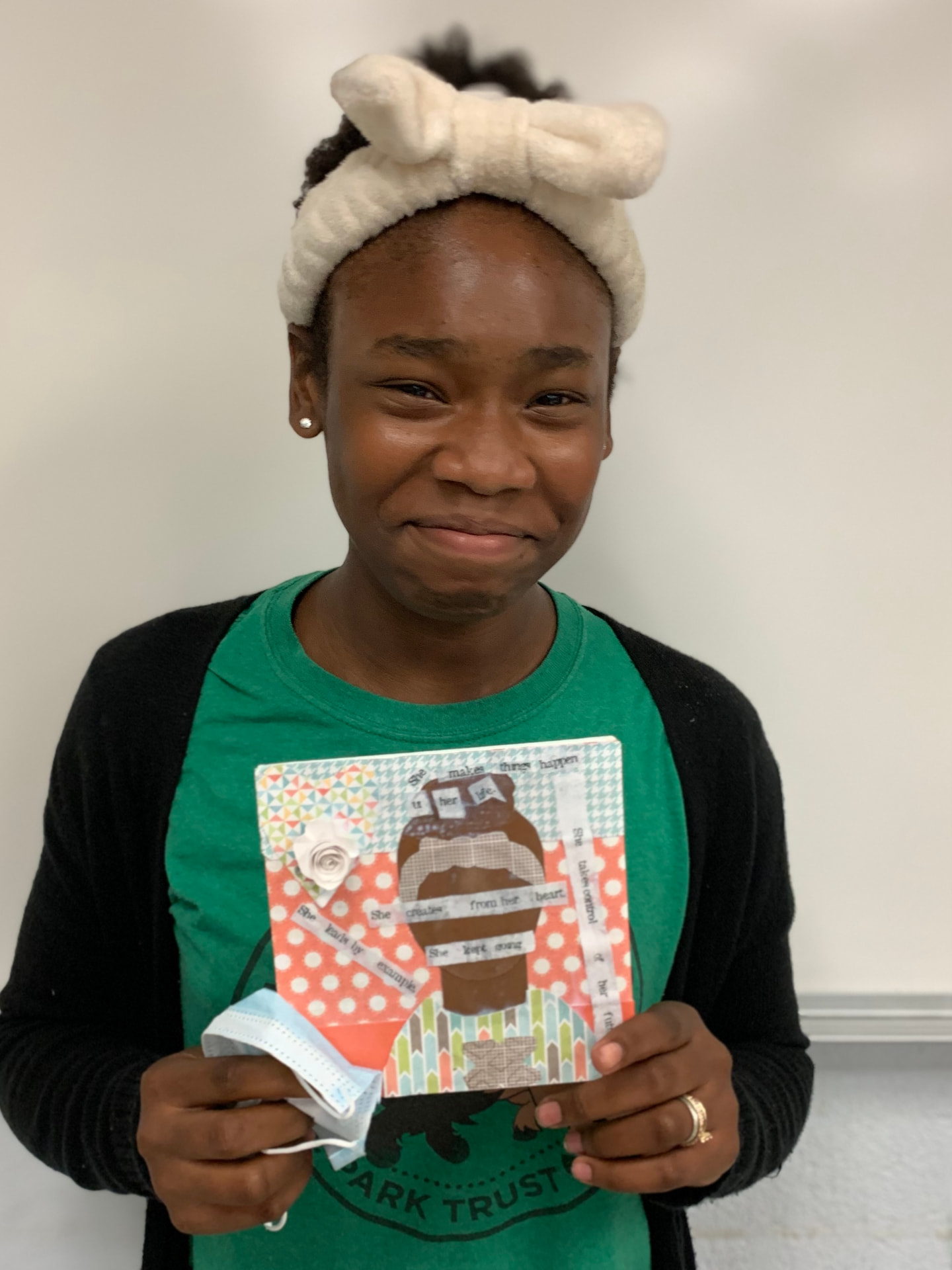 A young participant holds a collage reading 'She makes things happen in her life'.